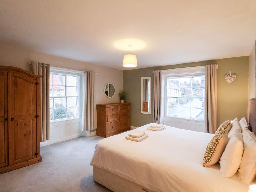 A bedroom with a bed and dresser at The Lodge in Snainton near Scarborough