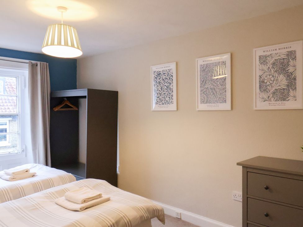 A bedroom with two beds and a wardrobe at The Lodge in Snainton near Scarborough