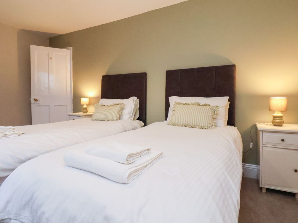 A bedroom with two beds and a nightstand at The Lodge in Snainton near Scarborough
