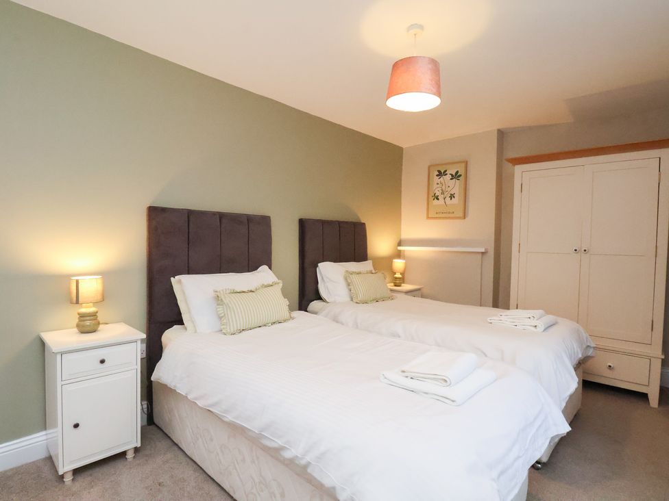 A bedroom with twin beds and bedside tables at The Lodge in Snainton near Scarborough