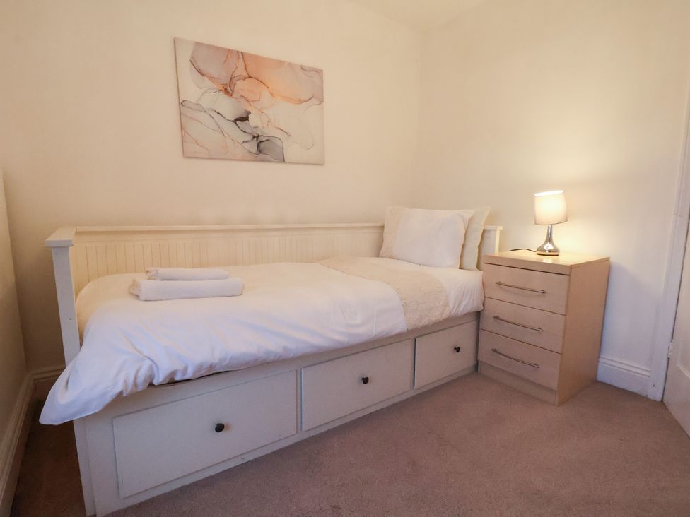 A bedroom with a single bed and bedside table at The Lodge in Snainton near Scarborough