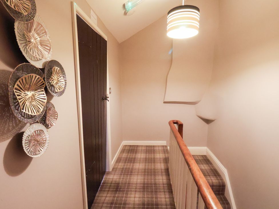A hallway with a door and wall decor at The Lodge in Snainton near Scarborough