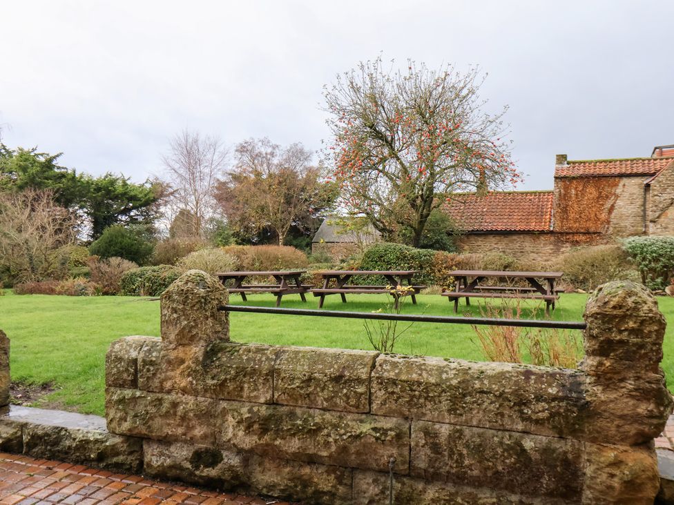 A garden with benches and trees at The Lodge in Snainton near Scarborough