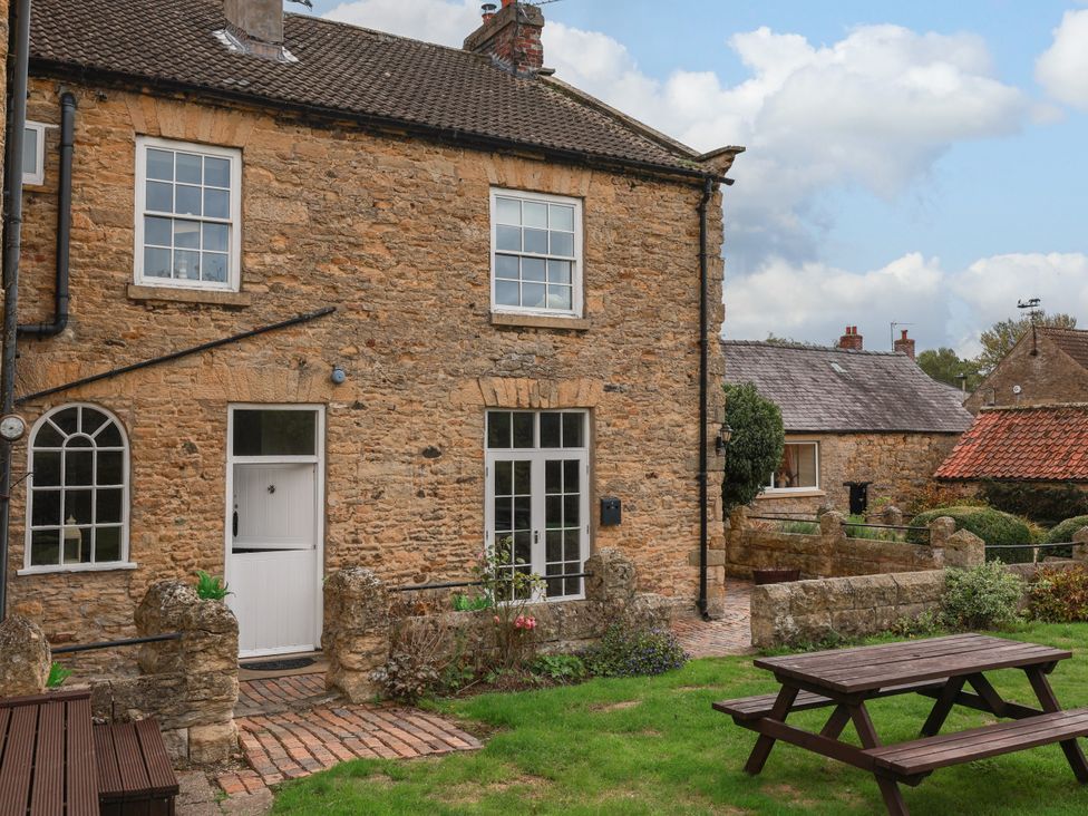 An outdoor view of a house with a garden at The Lodge in Snainton near Scarborough