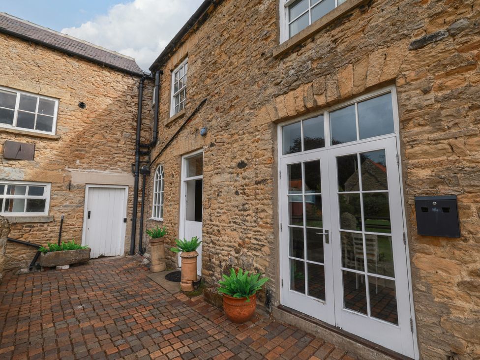 An outdoor area with stone walls and doors at The Lodge in Snainton near Scarborough