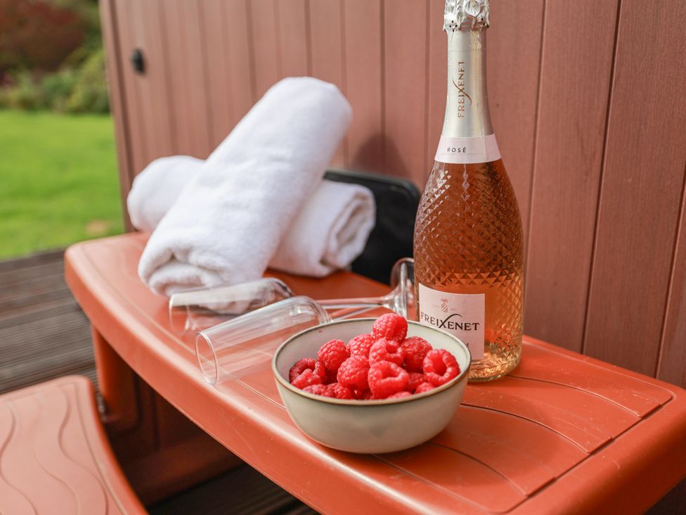 A bowl of raspberries and a bottle of champagne on a table at The Lodge in Snainton near Scarborough
