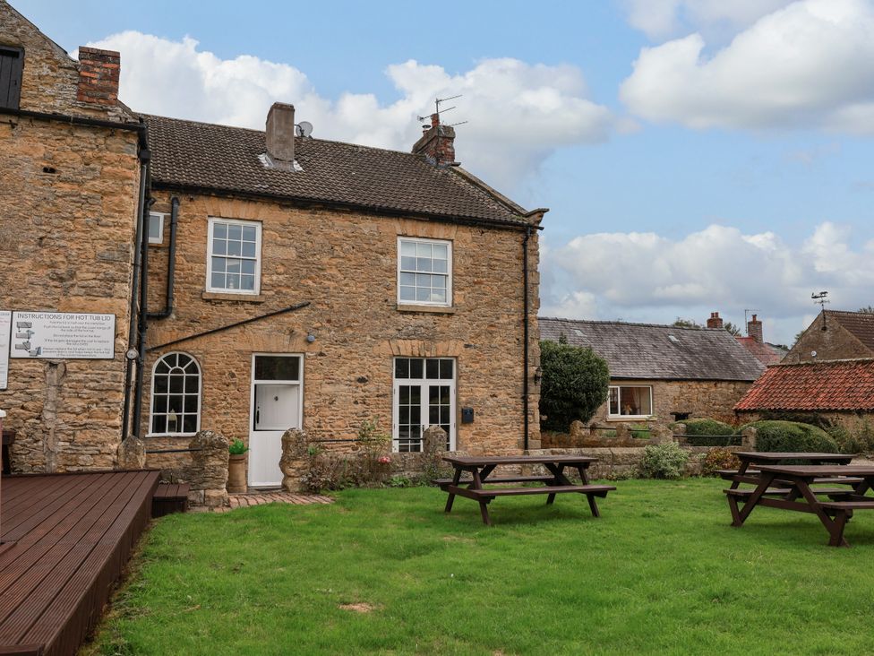 An outdoor view of a house with garden and seating at The Lodge Snainton near Scarborough