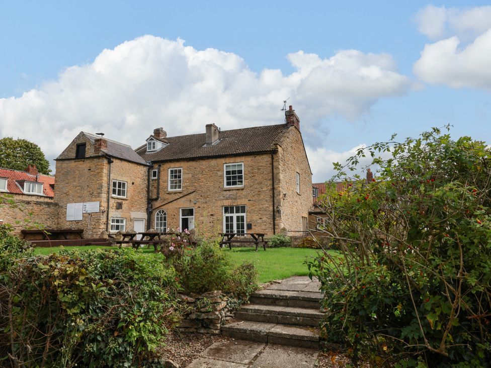 A building with tables and grass area at The Lodge in Snainton near Scarborough
