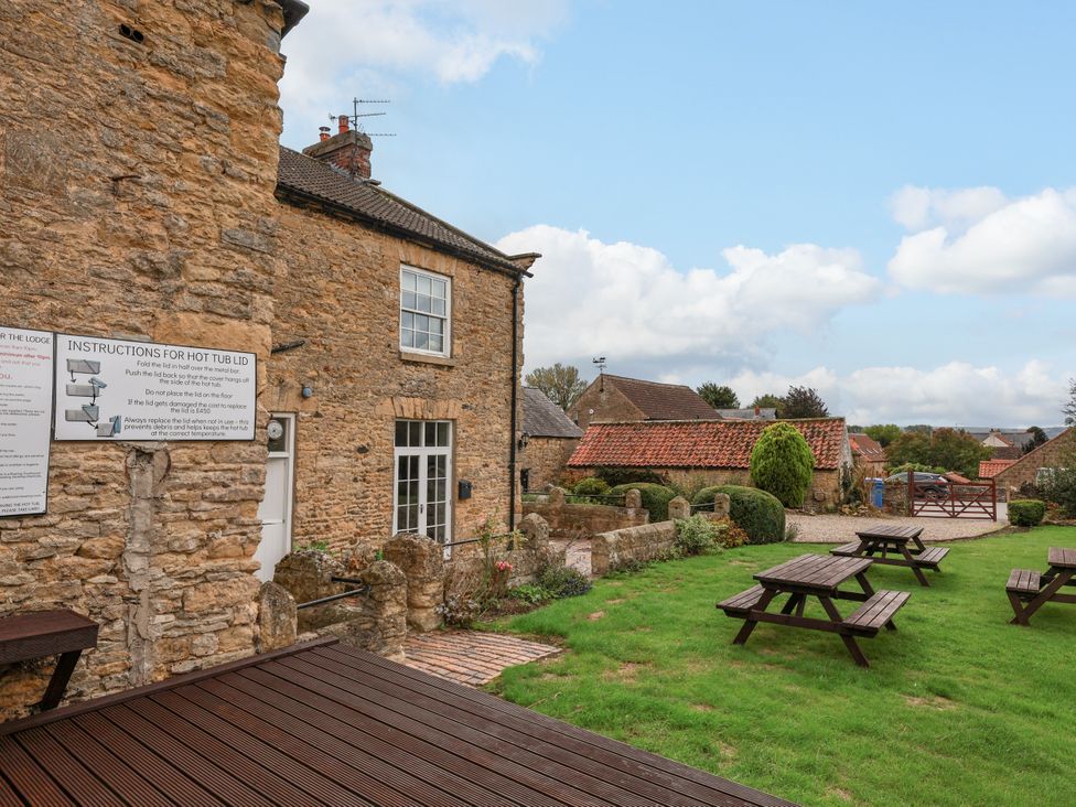 An outdoor area with stone building and seating arrangements at The Lodge Snainton near Scarborough