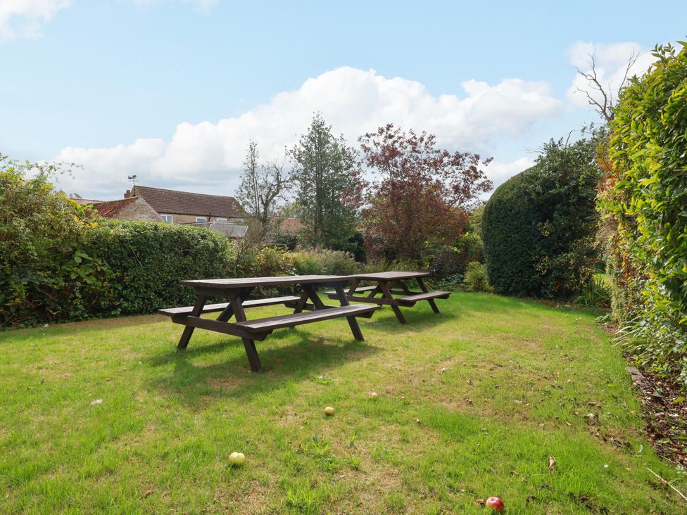A garden with a picnic table and trees at The Lodge in Snainton near Scarborough