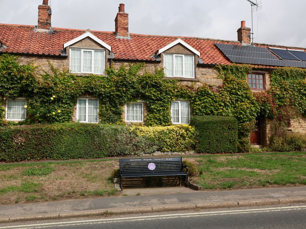 A house with windows and a garden bench at The Lodge in Snainton near Scarborough