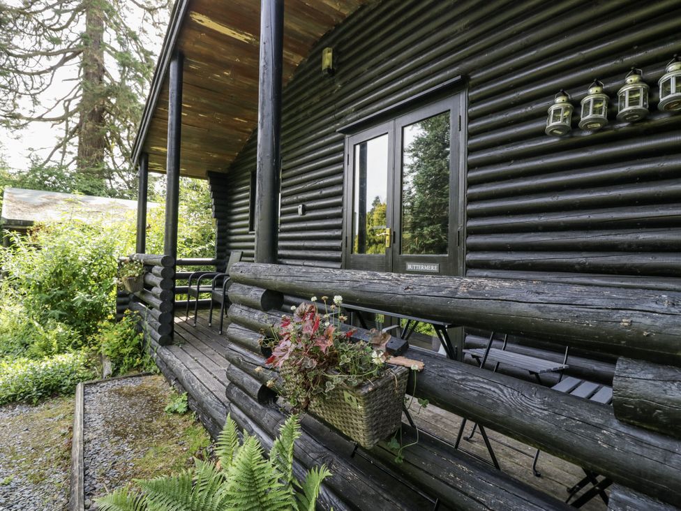 An outdoor patio with chairs and a planter at Buttermere in Spark Bridge near Greenodd