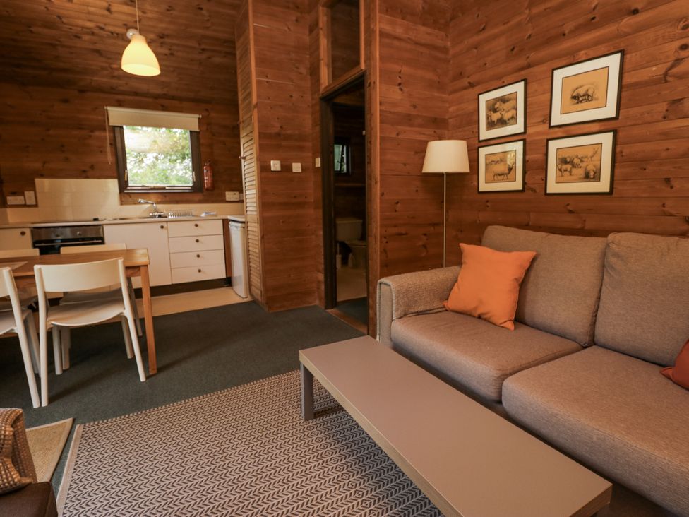 A living room with a sofa and dining area at Buttermere Spark Bridge near Greenodd