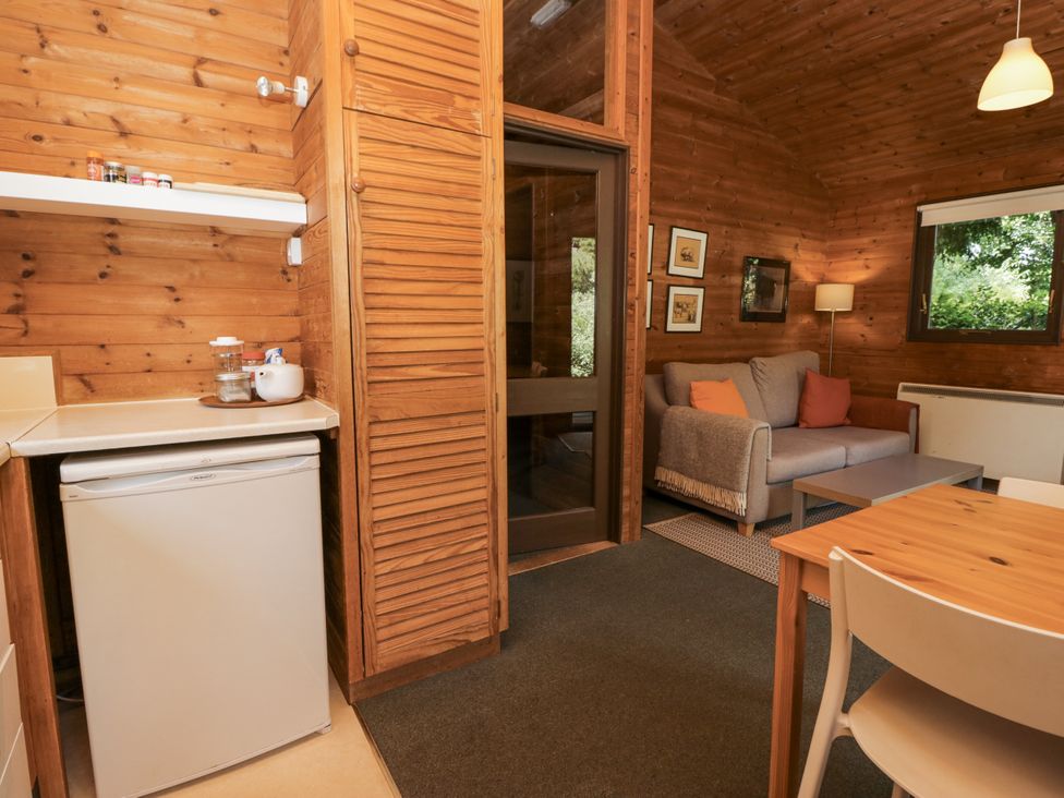 A living room with a sofa and refrigerator at Buttermere Spark Bridge near Greenodd