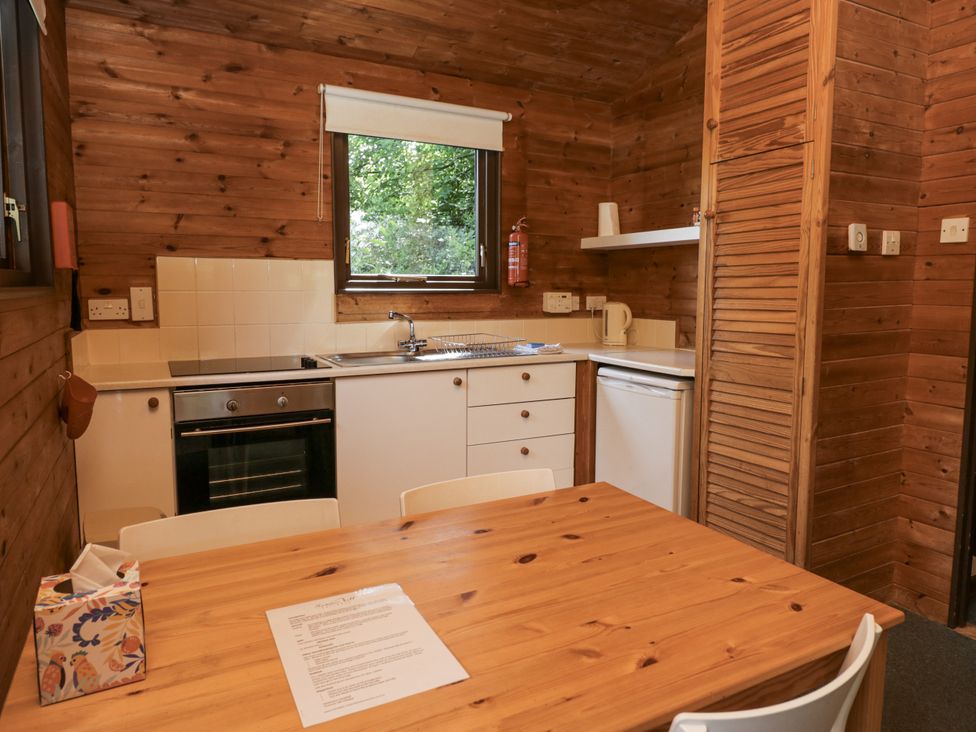 A kitchen with an oven, sink, and table at Buttermere, Spark Bridge near Greenodd