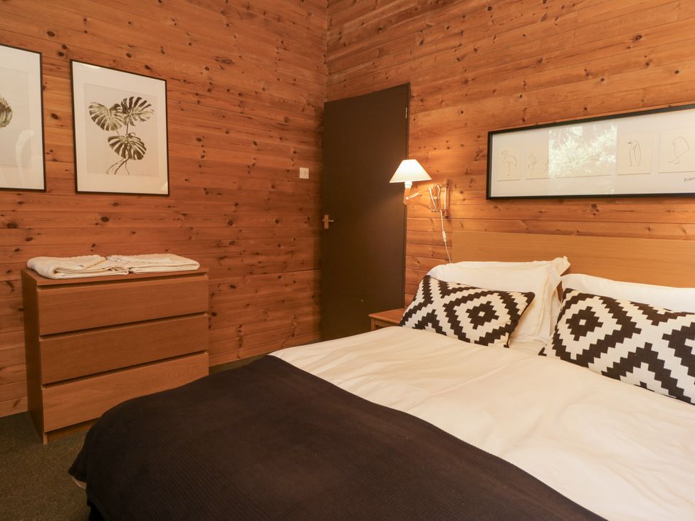 A bedroom with a bed and bedside lamp at Buttermere Spark Bridge near Greenodd