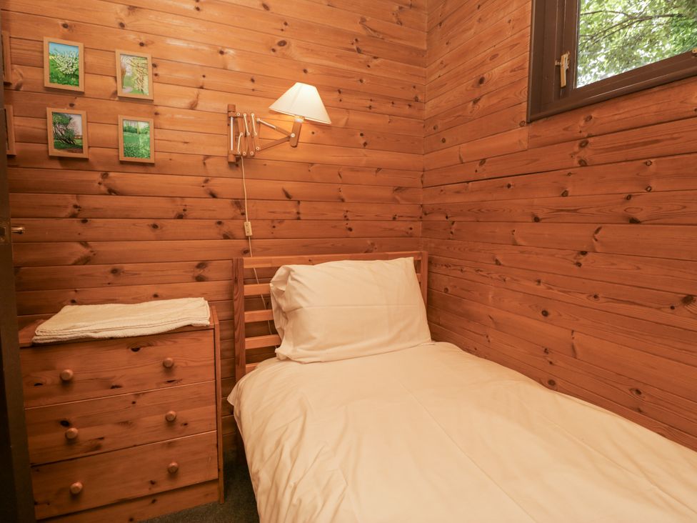 A bedroom with a single bed and wall-mounted lamp at Buttermere Spark Bridge near Greenodd