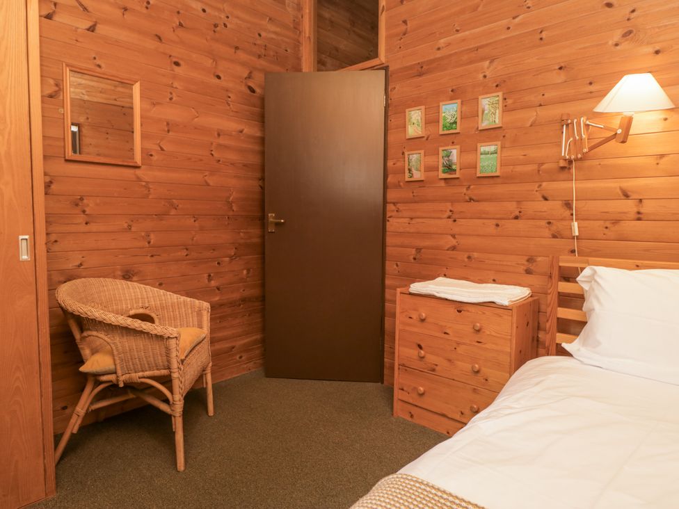 A bedroom with wood walls and a bed at Buttermere in Spark Bridge near Greenodd