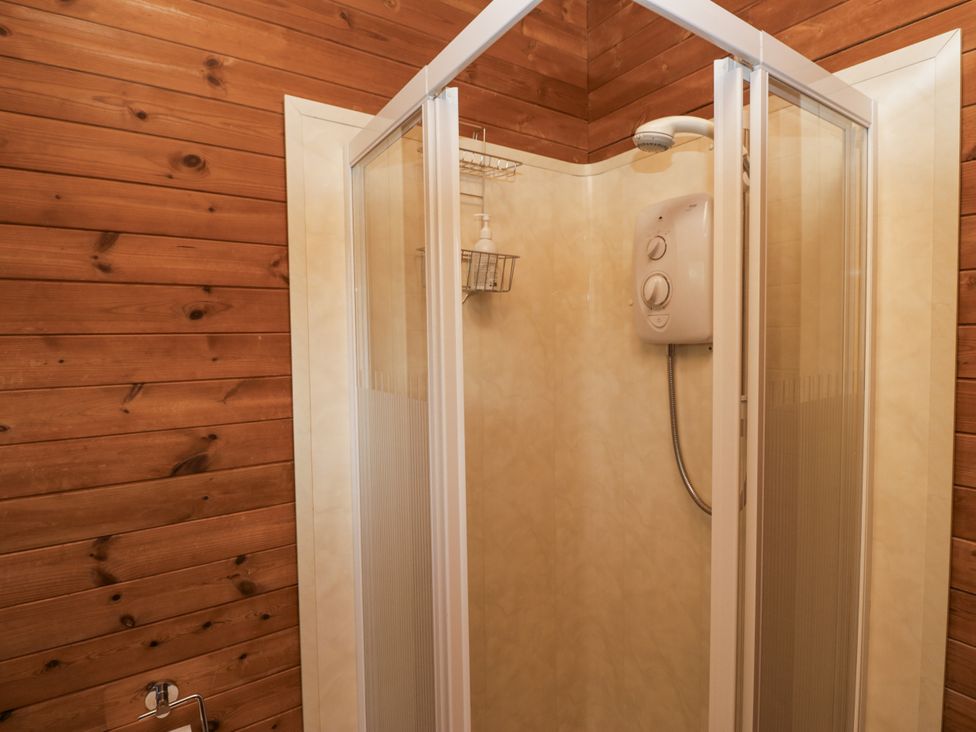 A shower with a water heater and shelf at Buttermere in Spark Bridge near Greenodd