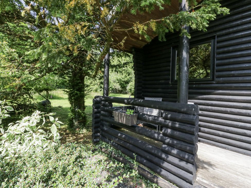 A deck with logs and a railing at Grasmere in Spark Bridge near Greenodd
