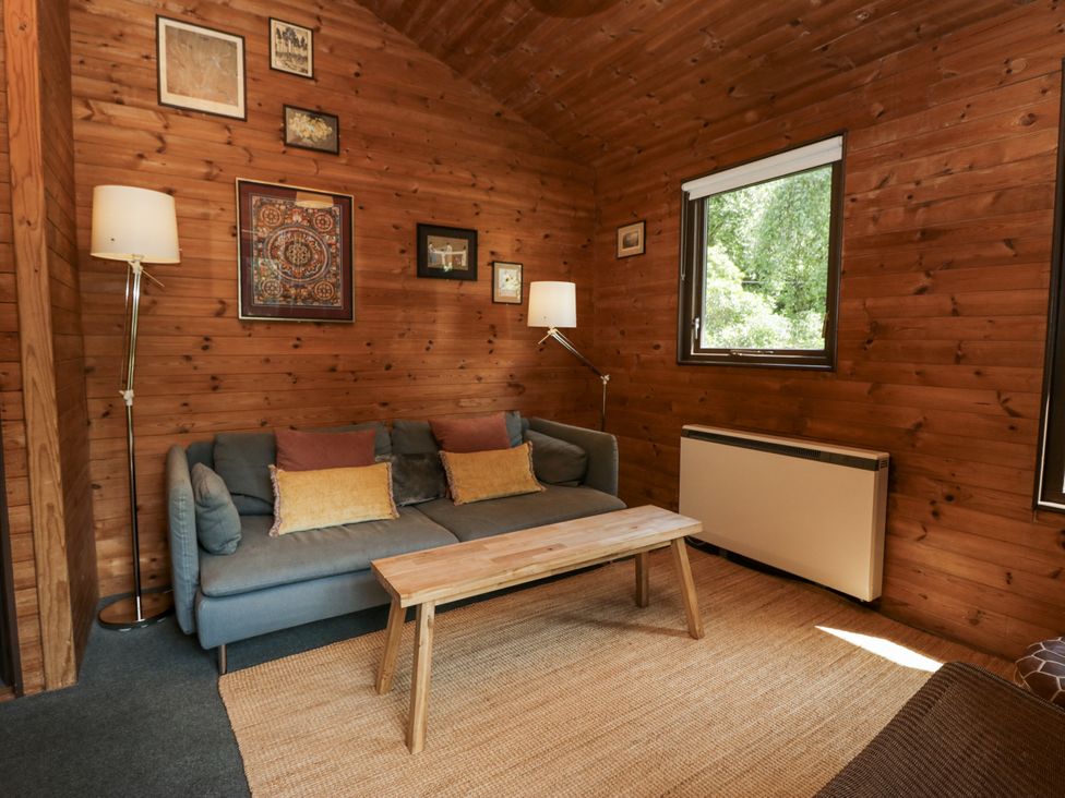 A living room with a sofa and coffee table at Grasmere in Spark Bridge near Greenodd