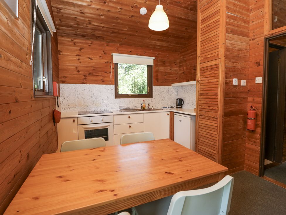 A kitchen with a wooden table and chairs at Grasmere in Spark Bridge near Greenodd