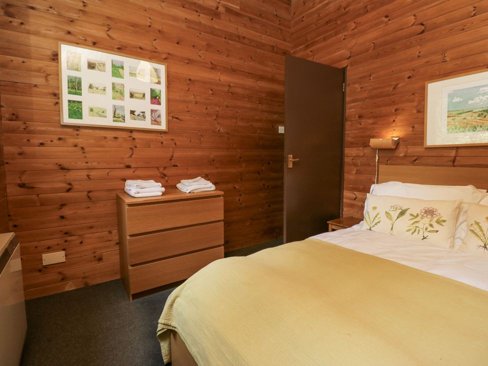 A bedroom with a bed and chest of drawers at Grasmere in Spark Bridge near Greenodd