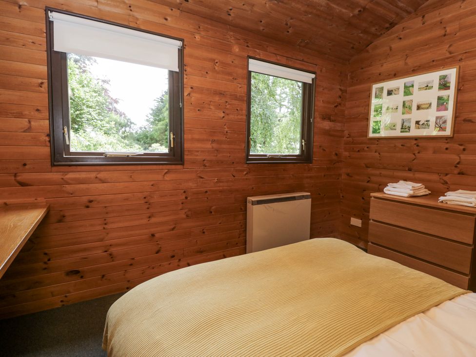 A bedroom with windows and a dresser at Grasmere in Spark Bridge near Greenodd
