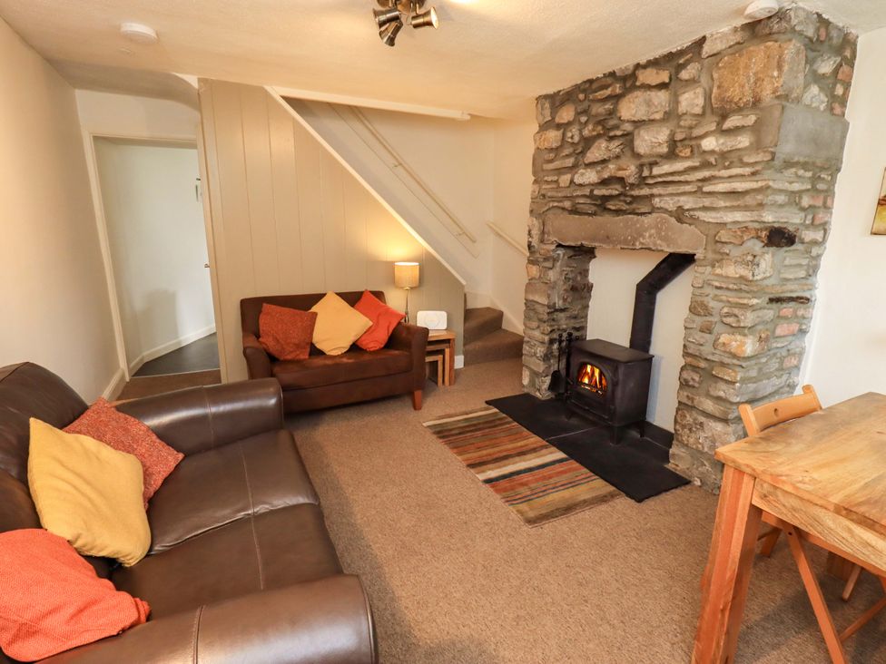 A living room with a sofa and fireplace at Back Cottage in Kirkby Lonsdale