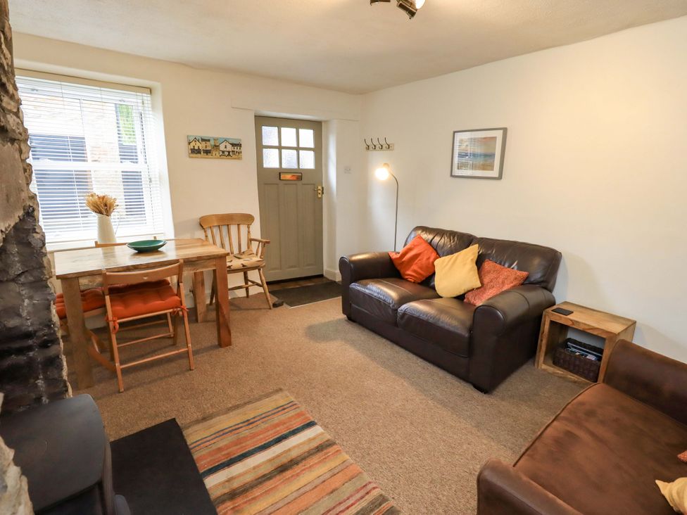 A living room with a sofa, table and chairs at Back Cottage in Kirkby Lonsdale