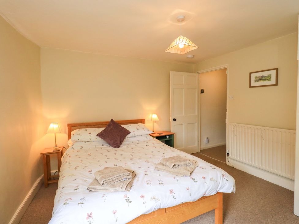 A bedroom with a bed and bedside table at Back Cottage in Kirkby Lonsdale