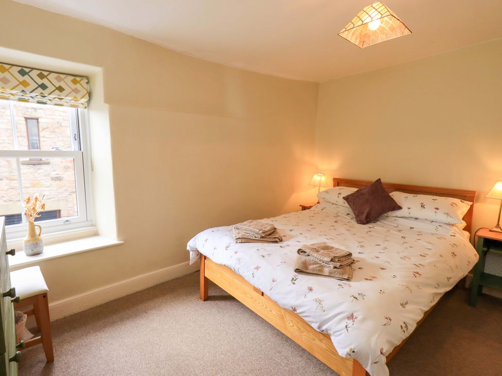 A bedroom with a bed and a window at Back Cottage Kirkby Lonsdale