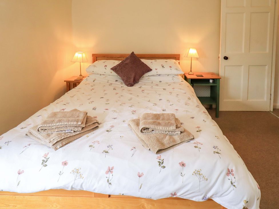 A bedroom with a bed and towels on top at Back Cottage in Kirkby Lonsdale