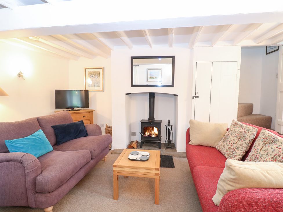 A living room with a wood-burning stove and a television at Broom Cottage East Rudham near Fakenham