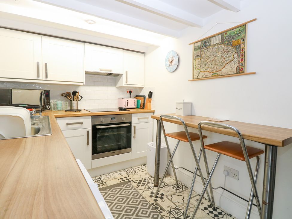 A kitchen with appliances and seating at Broom Cottage in East Rudham near Fakenham