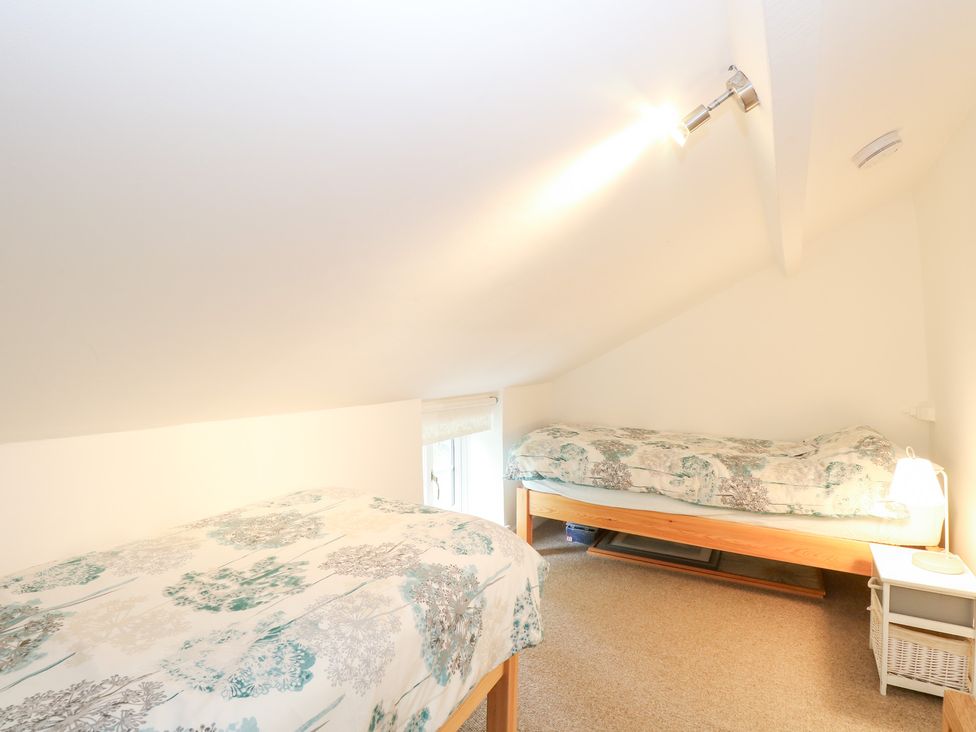 A bedroom with two beds and a window at Broom Cottage in East Rudham near Fakenham
