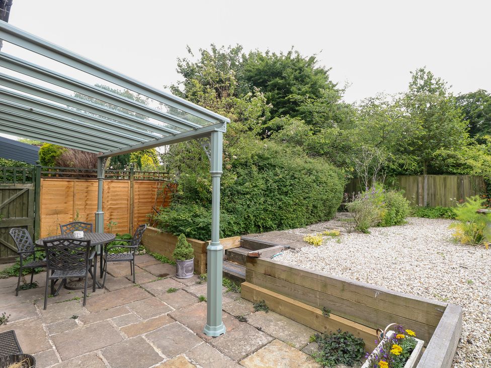 A garden with a patio area and table at Broom Cottage East Rudham near Fakenham