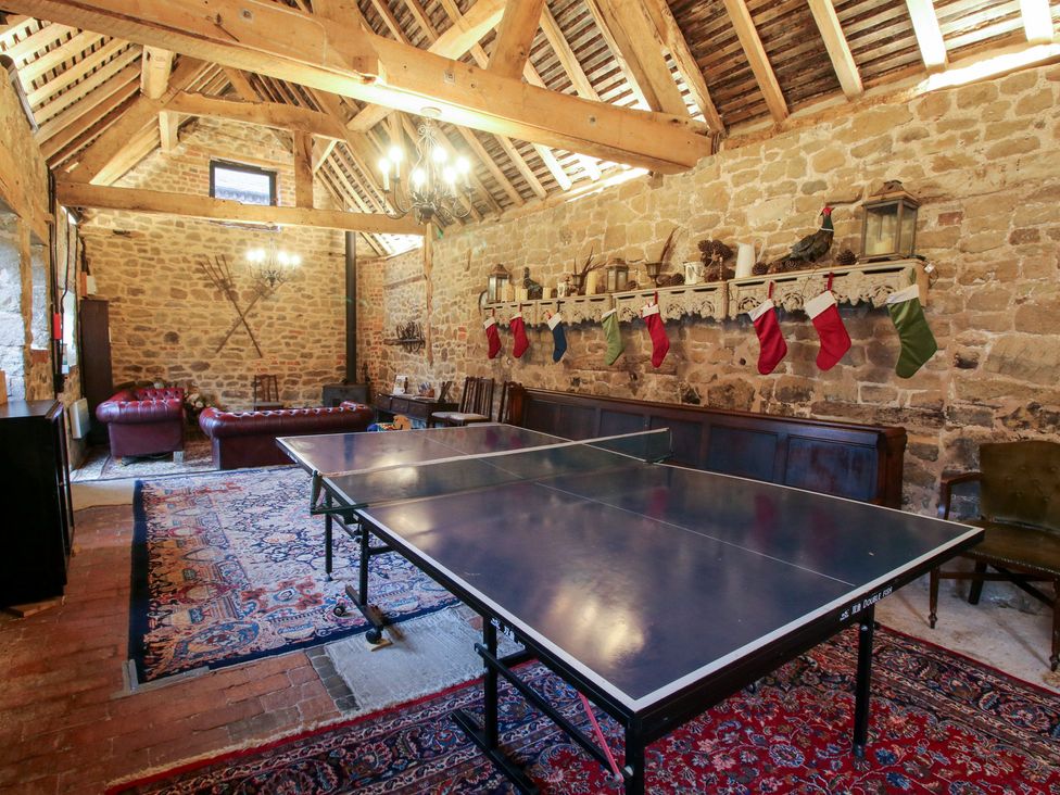 A game room with a table tennis table and sofa at The Olde Cow House in Cardington