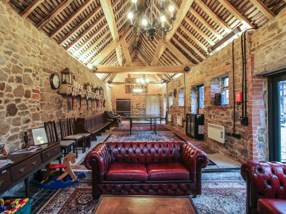 A day room with a sofa and table at The Olde Cow House in Cardington
