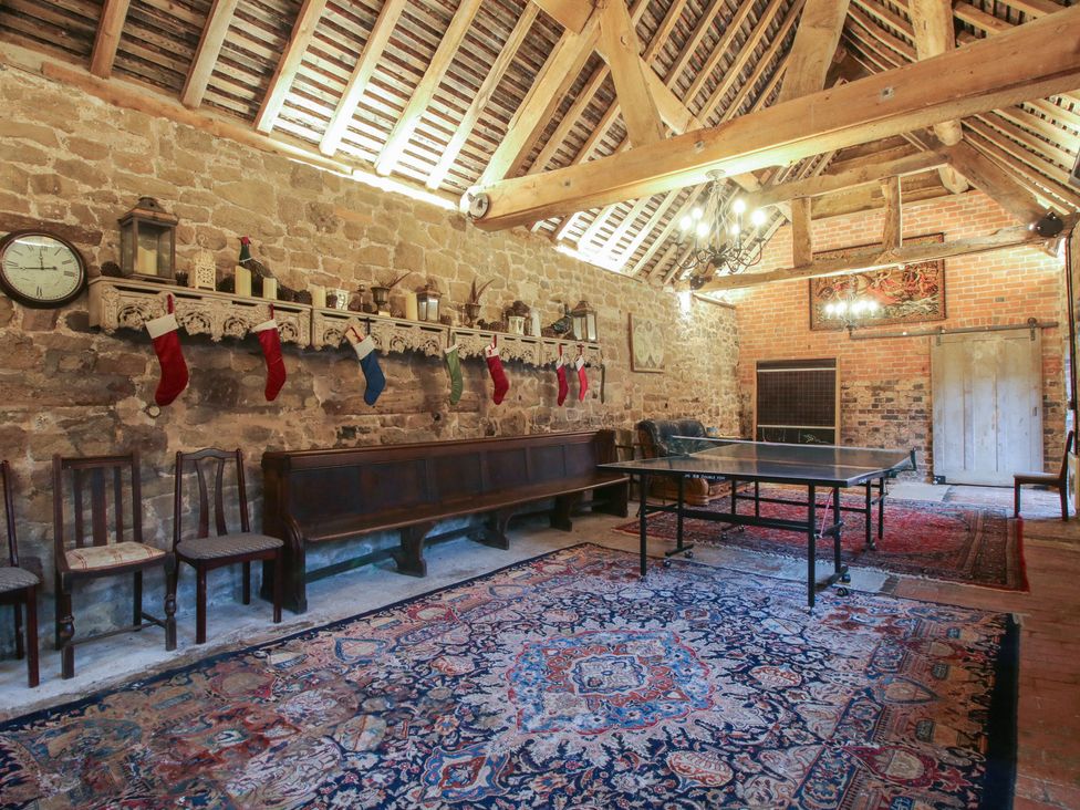 A recreation room with a table and chairs at The Olde Cow House in Cardington