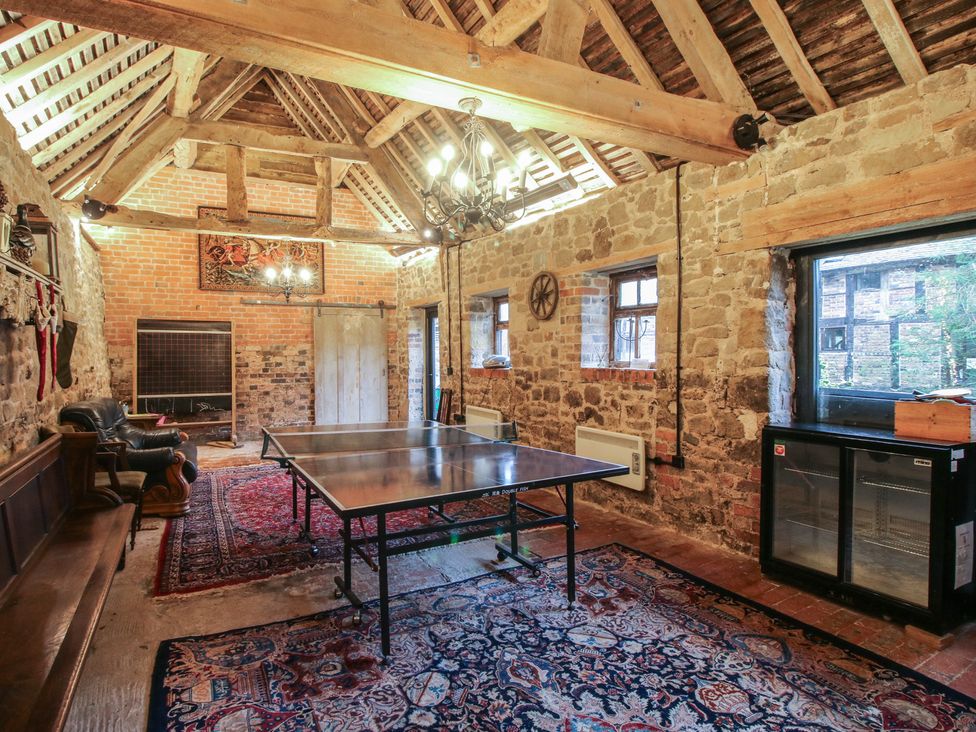 A game room with a ping pong table and stone walls at The Olde Cow House in Cardington