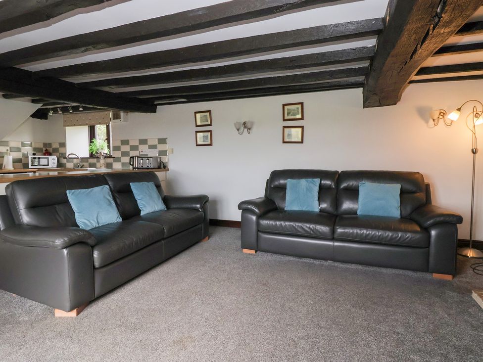 A living room with two sofas and kitchen area at Wethercote Cottage Old Byland near Helmsley