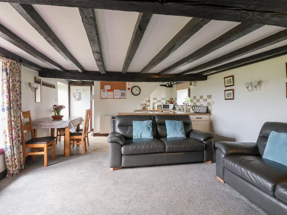 A living room with a sofa and dining area at Wethercote Cottage in Old Byland near Helmsley