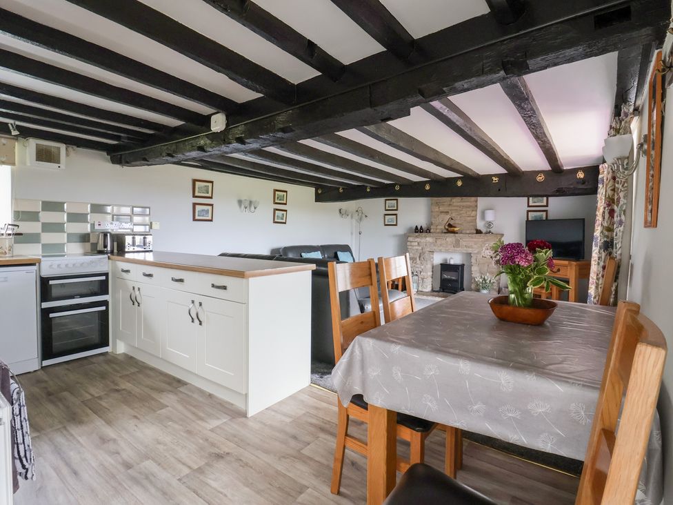 A living room and kitchen area with dining table and seating at Wethercote Cottage Old Byland near Helmsley