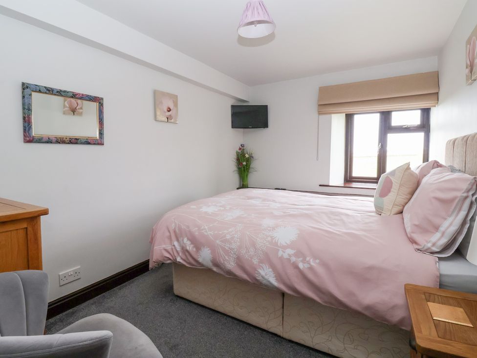 A bedroom with a bed and a television at Wethercote Cottage Old Byland near Helmsley