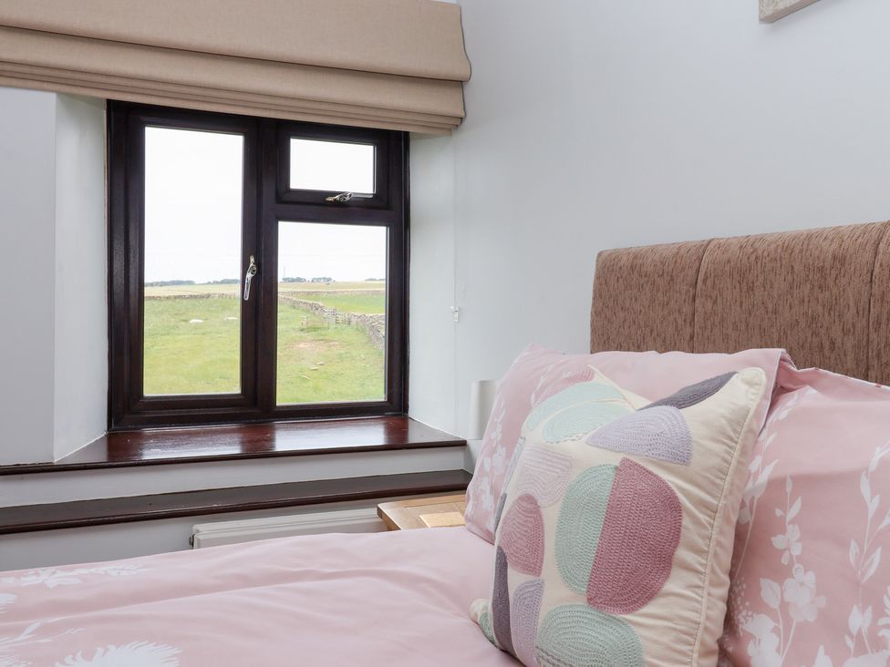 A bedroom with a window and bed at Wethercote Cottage in Old Byland near Helmsley