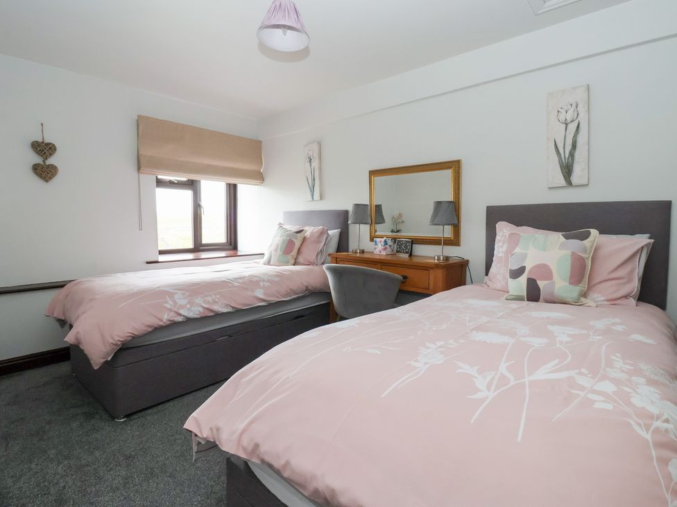 A bedroom with two beds and a desk at Wethercote Cottage Old Byland near Helmsley