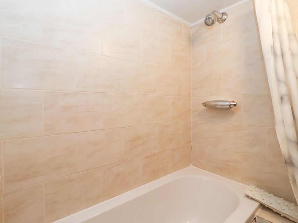 A bathroom with a bathtub and shower fixtures at Wethercote Cottage Old Byland near Helmsley