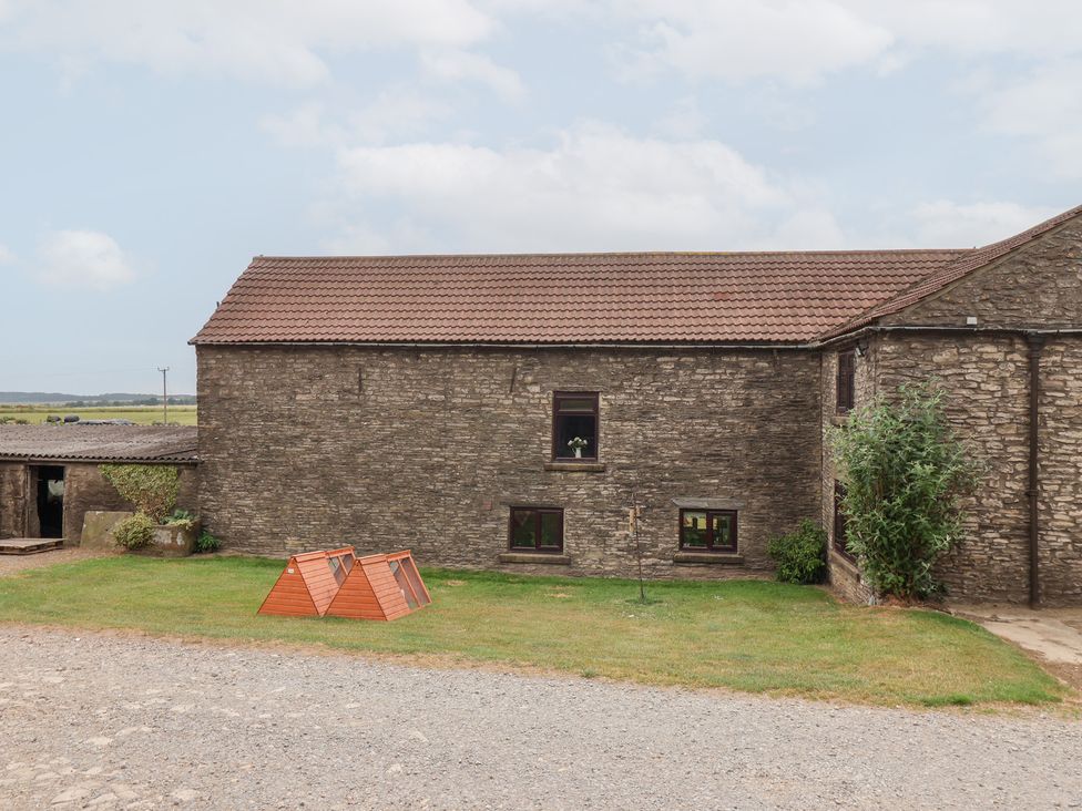 An outdoor area with a stone building and a pet house at Wethercote Cottage Old Byland near Helmsley