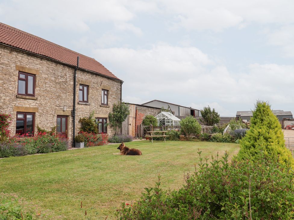 An outdoor setting with a stone house and garden at Wethercote Cottage in Old Byland near Helmsley